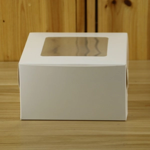 Macro shot of white cardboard muffin box featuring a clear window and inner tray