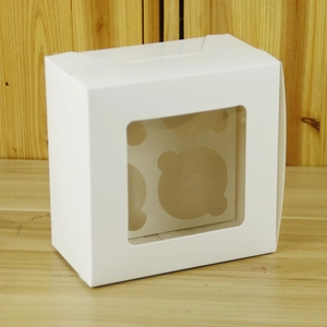 Close-up of white 4-slot cupcake box with clear window and removable cardboard insert