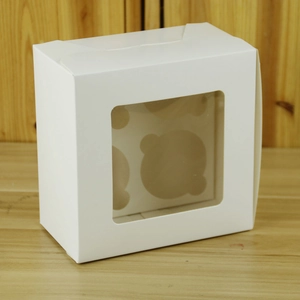 Close-up of white cupcake box with clear window and insert on a wooden surface