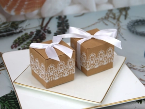 Detail of vintage kraft paper candy boxes with white lace print and silk ribbon bows