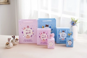 Dettaglio di sacchetti regalo baby shower rosa e blu con nastri e motivi animali