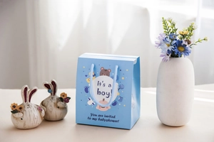 Dettaglio del sacchetto regalo azzurro per baby shower con orsetto e manici in corda