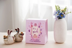 Sacchetto regalo rosa 'It's a girl' per baby shower con disegni carini e manici in cotone