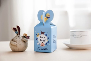 Dettaglio scatola regalo baby shower azzurra con ritaglio di anatra e scritta 'It's a boy'