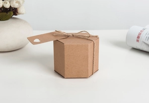 Close-up of hexagonal kraft gift box with heart-shaped tag and natural hemp rope