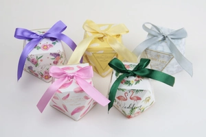 Detail of octagonal paper wedding favor boxes with satin ribbon bows in various patterns