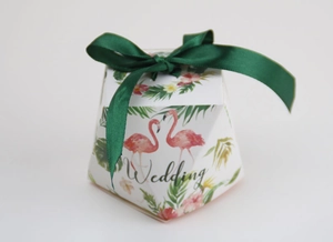 Detail of octagonal wedding favor box with flamingo prints and green satin bow