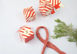 Detail van rood-wit gestreepte adventskalender geschenkdoos met goudfolie nummer twee