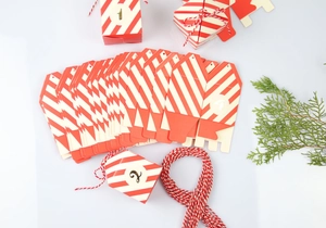 Detailopname van DIY adventkalender doosjes met rood-witte strepen en gouden nummering
