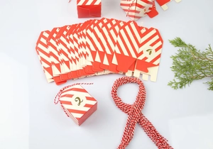 Detail van rood en wit gestreepte DIY adventskalenderdozen met gouden cijfers