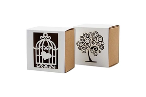 Detailed laser-cut tree and birdcage patterns on hollow white and kraft candy gift boxes