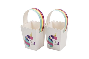 Detail of unicorn themed paper gift bags with rainbow handles and wavy cut edges