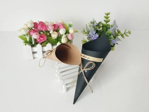 Detail of kraft paper cone bouquets in black and brown with twine bows and stickers