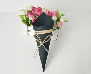 Detail of a black cone-shaped flower packaging box with Especially For You label and twine bow