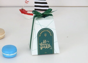 Details einer trapezförmigen Hochzeits-Geschenkbox mit waldgrünem Band und Golddruck