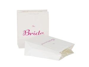 Close-up of white wedding gift bags with pink Bride and Bridesmaid lettering