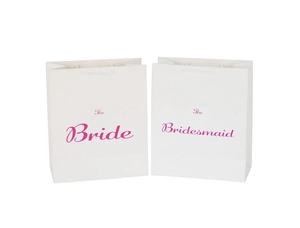 Detail of white wedding gift bags with pink The Bride and The Bridesmaid lettering