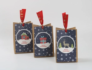 Detailed view of blue Christmas kraft paper bags with festive reindeer patterns and ribbons