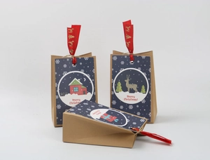 Close-up of Christmas kraft paper gift bags with blue cards and red ribbons