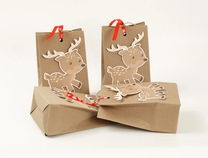 Detail of Christmas reindeer kraft paper gift bags with red snowflake ribbons and twine handles