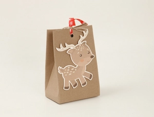 Close-up of brown kraft paper gift bag with reindeer cutout and snowflake ribbon