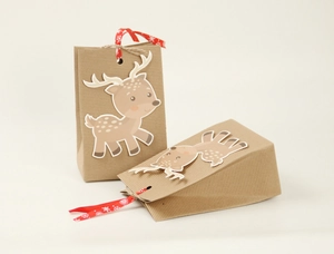 Detail of Christmas reindeer kraft paper gift bag with festive red snowflake ribbon