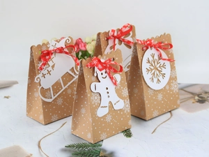 Sacchetti di Natale in carta kraft con fiocchi di neve, nastri rossi e biglietti festivi