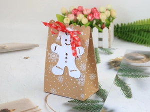 Dettaglio del sacchetto regalo di Natale in carta kraft con cartellino e fiocco rosso