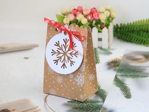 Sacchetto regalo di Natale in carta Kraft con fiocchi di neve e nastro rosso