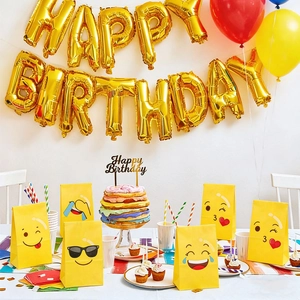 Macro shot of yellow Emoji paper gift bags against a festive birthday party backdrop