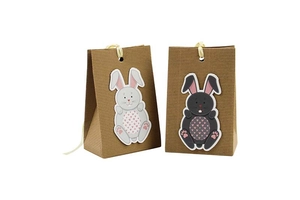 Detail of kraft paper Easter bunny gift bags with gray and black rabbit designs and ribbons