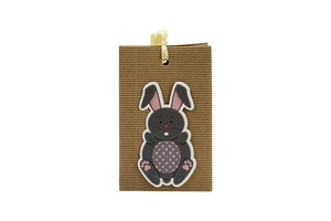 Detail of kraft corrugated paper gift bag with cartoon bunny and yellow ribbon handle