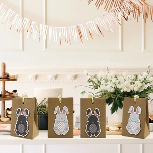 Detail of four Easter bunny kraft paper gift bags with pink hearts and gold ribbons