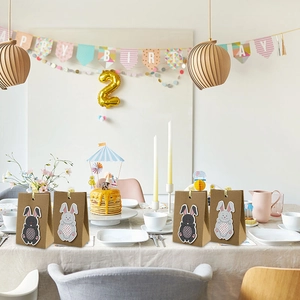 Close-up of Easter rabbit gift bags with paper stripes and cute cartoon bunny tags