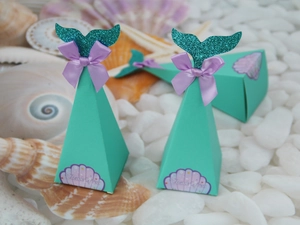 Detail of mermaid themed pyramid candy boxes with teal glitter tail and silk ribbon