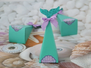 Detail of teal mermaid party favor box with glitter tail and purple thank you sticker