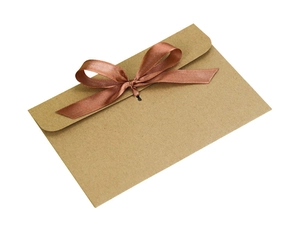 Detail of vintage kraft paper envelope with decorative bronze satin ribbon bow