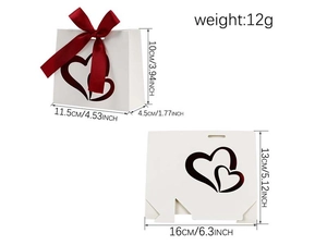 Detailed view of white paper gift bag with red ribbon, heart cutouts, and dimensions