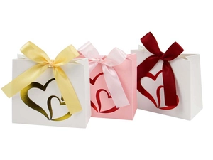 Detailed view of gift bags featuring gold double heart patterns and satin ribbon bows