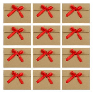 Set of 12 kraft paper envelopes with red silk ribbon bows in a neat grid arrangement
