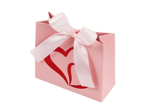Pink gift bag with golden hearts and a large silk bow for Valentine's Day favors