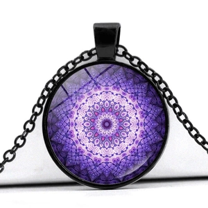 Detailed close-up of a purple mandala glass cabochon pendant with a black metal frame