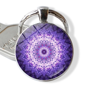 Macro view of silver mandala keychain with purple glass cabochon and metal keyring