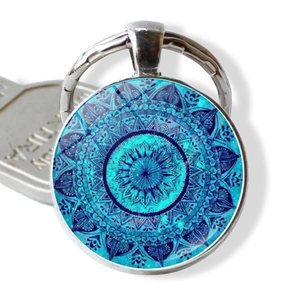 Macro detail of a blue mandala glass cabochon keychain with a silver metal base