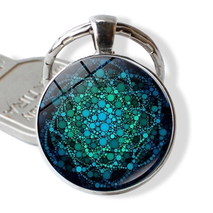 Silver yoga mandala flower keychain with blue glass pendant and geometric dot art pattern