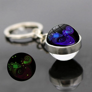 Close-up of luminous crystal ball keychain with glow-in-the-dark zodiac constellation effect