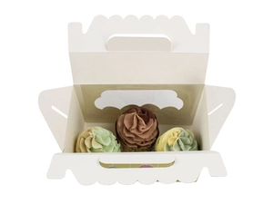 Vue de haut d'une boîte cadeau de Pâques avec fenêtre et trois cupcakes colorés décorés