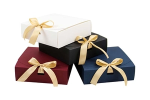 Detail quadratischer Geschenkschachteln mit goldenen Bändern in Weiß, Schwarz, Rot und Blau