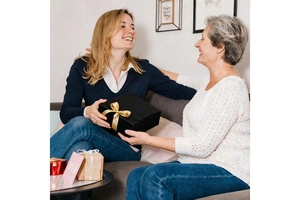 Nahaufnahme einer schwarzen quadratischen Geschenkbox mit goldener Satinschleife