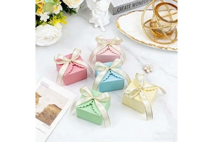 Close-up of European square candy boxes with wavy edges and elegant beige bow ribbons